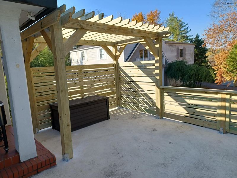 Cedar pergola over a concrete patio with new railing
