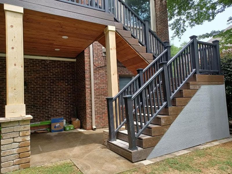 Under-deck patio with finished ceiling, brick columns and metal railing